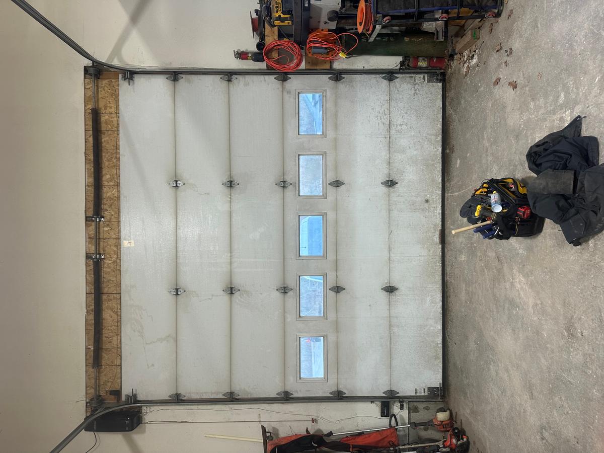 Interior commercial sectional door with four vertical windows and side-mounted opener